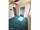 Bedroom featuring plush green carpeting, a ceiling fan, and a spacious closet at 5016 W Sunrise Dr, Laveen, AZ 85339