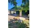 View of a property with a covered parking area and greenery, shaded by a tree at 5016 W Sunrise Dr, Laveen, AZ 85339