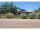 A charming home with a lush, green, and well-maintained front yard, surrounded by bushes and trees at 5016 W Sunrise Dr, Laveen, AZ 85339