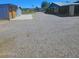 Exterior view of the property featuring multiple outbuildings and a large gravel yard at 5016 W Sunrise Dr, Laveen, AZ 85339