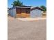 An outbuilding featuring wood and corrugated metal siding and a gravel driveway at 5016 W Sunrise Dr, Laveen, AZ 85339