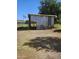 Exterior view of outbuilding with corrugated metal siding and gravel yard on sunny day at 5016 W Sunrise Dr, Laveen, AZ 85339