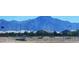 A wide street view captures a peaceful residential area with mountains in the background and sidewalks ready to explore at 5016 W Sunrise Dr, Laveen, AZ 85339
