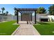 Lush backyard featuring an outdoor kitchen area, a pergola and manicured lawn for relaxation and entertainment at 5259 E Karen Dr, Scottsdale, AZ 85254