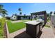 This backyard has artifical grass, outdoor kitchen, pergola, and a home with solar panels at 5259 E Karen Dr, Scottsdale, AZ 85254