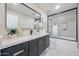 Modern bathroom with stylish black and white tiling, vanity with large mirror, and glass shower door at 5259 E Karen Dr, Scottsdale, AZ 85254