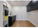 Functional laundry room with modern black cabinetry, a utility sink, and sleek hardwood flooring at 5259 E Karen Dr, Scottsdale, AZ 85254