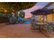 Spacious backyard with a dining table, patio chairs, patio umbrella, and a sparkling in-ground pool at 5930 E Fountain St, Mesa, AZ 85205