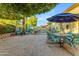Spacious backyard area with tiled ground, featuring outdoor furniture and lush trees around the pool area at 5930 E Fountain St, Mesa, AZ 85205