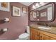 Charming powder room with wood vanity, granite countertop, decorative mirror, and unique wall decor at 5930 E Fountain St, Mesa, AZ 85205