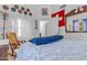 Light-filled bedroom features a bed with patterned linens, white closet doors, and eclectic decor at 5930 E Fountain St, Mesa, AZ 85205