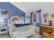Cozy bedroom with blue accent wall, a patterned bedspread, and vintage-style furnishings at 5930 E Fountain St, Mesa, AZ 85205