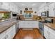 Bright kitchen with stainless steel appliances, white cabinets, granite countertops, and hardwood floors at 5930 E Fountain St, Mesa, AZ 85205