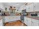 Kitchen with stainless steel appliances, white cabinets, granite countertops, and hardwood floors at 5930 E Fountain St, Mesa, AZ 85205