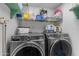 Efficient laundry area with modern front-load washer and dryer set and convenient shelving at 5930 E Fountain St, Mesa, AZ 85205