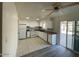 Efficient kitchen features white cabinets, tile flooring, and sliding door access to outdoor space at 6565 N 19Th Ave # 38, Phoenix, AZ 85015