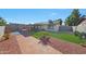 Charming backyard featuring a brick walkway, green lawn, small patio, and desert landscaping at 7132 W Vermont Ave, Glendale, AZ 85303