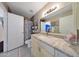 Well-lit bathroom features a granite vanity, large mirror, and neutral-colored tile flooring at 7132 W Vermont Ave, Glendale, AZ 85303
