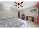 Well-lit bedroom featuring neutral walls, ceiling fan, tiled flooring, built-in shelves, and desk space at 7132 W Vermont Ave, Glendale, AZ 85303