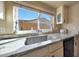 Bright kitchen featuring white cabinets, stainless steel sink, and a window view of the backyard at 7132 W Vermont Ave, Glendale, AZ 85303