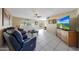 Inviting living room with tile flooring, comfortable seating, and a wall-mounted television at 7132 W Vermont Ave, Glendale, AZ 85303