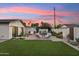 Beautiful backyard with a well-manicured lawn, patio, cozy lounge chairs, and a pergola at 7432 E Holly St, Scottsdale, AZ 85257