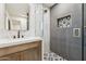 Modern bathroom featuring a marble shower, unique tile design, and wooden vanity at 7432 E Holly St, Scottsdale, AZ 85257