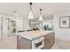 A stylish kitchen island featuring marble countertops, a built-in oven, and seamless flow into the living and dining areas at 7432 E Holly St, Scottsdale, AZ 85257