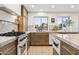 Modern kitchen with stainless steel appliances, marble countertops, and ample natural light from the adjacent windows at 7432 E Holly St, Scottsdale, AZ 85257