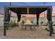 Outdoor dining under a modern pergola with shaded seating amidst a serene, landscaped backyard setting at 7432 E Holly St, Scottsdale, AZ 85257