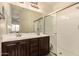Bathroom featuring double sinks with a dark wood vanity, a large mirror, and a glass-enclosed shower at 7726 E Baseline Rd # 154, Mesa, AZ 85209