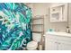Bright bathroom with a palm-leaf shower curtain, mirrored cabinet, and ample shelving at 8532 E Portland St, Scottsdale, AZ 85257