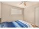 Bright bedroom showcasing wood-look floors, ceiling fan, and a blue and white striped bedspread at 8532 E Portland St, Scottsdale, AZ 85257