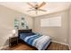 Cozy bedroom with a blue and white striped bedspread, ceiling fan, and wood-look flooring at 8532 E Portland St, Scottsdale, AZ 85257
