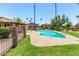 Community pool with a clear blue pool deck surrounded by palm trees and green lawns at 8532 E Portland St, Scottsdale, AZ 85257