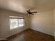 Bedroom featuring hard wood floors, a ceiling fan, and a window view to the exterior of the property at 9402 N 48Th Dr, Glendale, AZ 85302