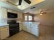 Spacious eat-in kitchen with white cabinets, modern appliances, and breakfast bar overlooking living area at 9402 N 48Th Dr, Glendale, AZ 85302