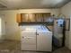 Functional laundry room equipped with washer, dryer, upper storage cabinets, and water heater at 9402 N 48Th Dr, Glendale, AZ 85302