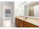 Bathroom featuring a single sink vanity, large mirror, and white tiled flooring at 11358 E Jenan Dr, Scottsdale, AZ 85259