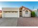 Home's exterior showcases desert landscaping, red-tiled roof, and attached two-car garage at 11358 E Jenan Dr, Scottsdale, AZ 85259