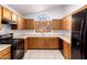 Kitchen with wooden cabinets, black appliances, light countertops, and tile floors at 11358 E Jenan Dr, Scottsdale, AZ 85259