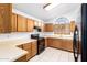 Kitchen with wooden cabinets, black appliances, light countertops, and tile floors at 11358 E Jenan Dr, Scottsdale, AZ 85259