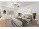 The staged primary bedroom boasts neutral tones, a ceiling fan, and ample natural light at 11358 E Jenan Dr, Scottsdale, AZ 85259
