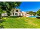 Lush backyard featuring a spacious lawn, mature trees, and a private swimming pool at 119 E Palomino Dr, Tempe, AZ 85284