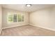 Empty bedroom featuring neutral colors, plantation shutters, carpeted floors, and a large window at 119 E Palomino Dr, Tempe, AZ 85284