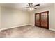 Spacious bedroom featuring plush carpet, ceiling fan, and beautiful shuttered French doors at 119 E Palomino Dr, Tempe, AZ 85284
