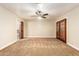 Large bedroom with neutral carpet, ceiling fan, and double doors at 119 E Palomino Dr, Tempe, AZ 85284