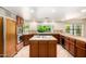 Bright kitchen with wood cabinets, stainless steel appliances, tile countertops, and a center island with a cooktop at 119 E Palomino Dr, Tempe, AZ 85284