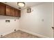 Laundry room with tile floors, overhead cabinets, and access to washer and dryer hookups at 119 E Palomino Dr, Tempe, AZ 85284