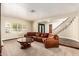 Inviting living room featuring neutral paint, large windows, staircase, and large leather sofa at 119 E Palomino Dr, Tempe, AZ 85284
